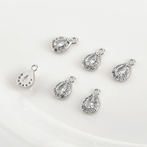 Macro view of six 14k white gold plated teardrop pendants with clear cubic zirconia