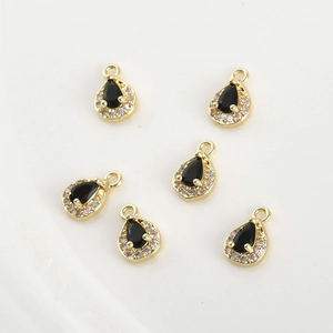 Close-up of 14k gold-filled teardrop pendants with black zircon and white crystals