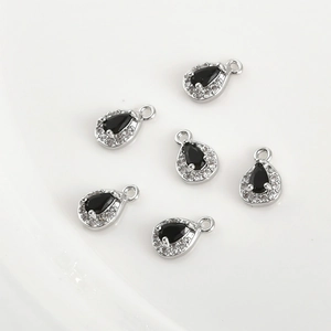 Macro view of six black teardrop charms with zircon borders for jewelry making