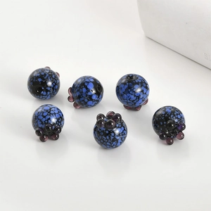 Macro shot of 6 handcrafted blue berry glass beads with glossy finish for jewelry making