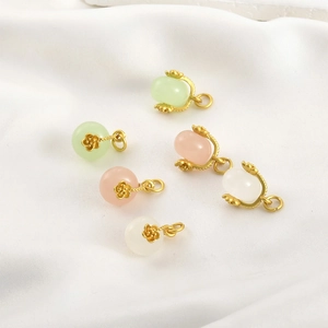 Ciondoli vintage in giada rosa oro 18k in vari colori su sfondo di seta bianca