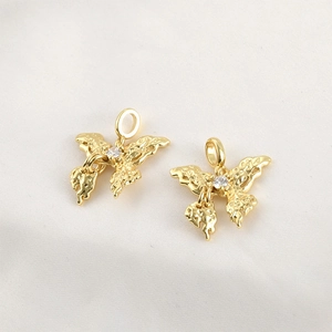 Macro detail of 18k gold plated butterfly pendants with lava texture and center crystal