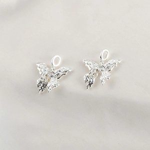 Close-up of S925 sterling silver butterfly pendants with lava texture and crystals