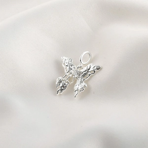 Detailed macro view of silver butterfly pendant with liquid metal lava texture and gemstone