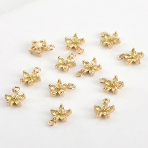Vue détaillée de 11 pendentifs fleurs à cinq pétales dorés avec pierres de zircon jaune