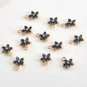 Vue détaillée de douze pendentifs fleurs à cinq pétales plaqués or avec zircons bleu foncé