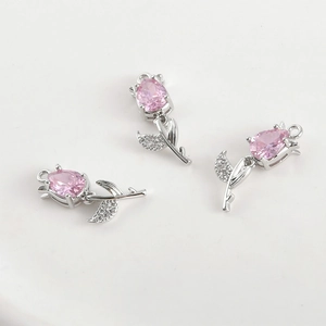 Macro detail of tulip pendant with 14k gold plating and pink zircon inlay charms