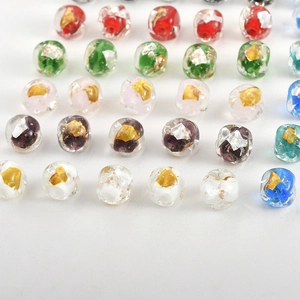 Detailed view of handmade square glass beads with embedded gold foil for jewelry making