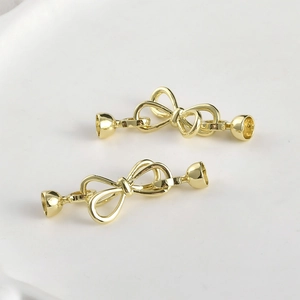 Detail of 14k gold-plated bow-shaped jewelry clasps for DIY pearl bracelets and necklaces