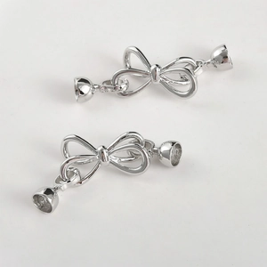 Close-up of polished silver bow-knot jewelry clasps for DIY pearl necklaces and bracelets