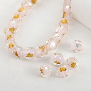Macro shot of pink glass beads with embedded gold and silver foil for DIY jewelry