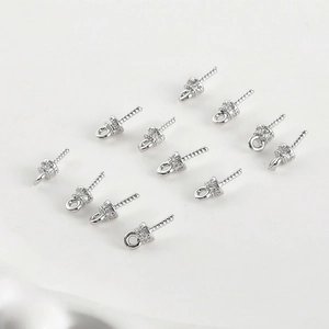 Makro-Detail von 12 versilberten Perlenanhänger-Ösen mit Zirkonia-Mikropavé-Fassung