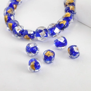 Detailed macro of handmade dark blue glass bead with internal gold and silver foil flakes