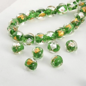 Macro detail of green handmade glass beads with gold and silver foil fragments inside