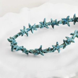Macro detail of starfish turquoise beads with vintage oil painting texture on tray