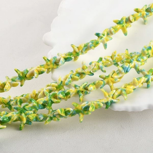 Detailed macro view of starfish-shaped turquoise beads with yellow and green oil painting texture