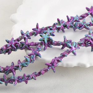 Macro shot of vintage starfish beads with purple and turquoise marbled texture on white ceramic