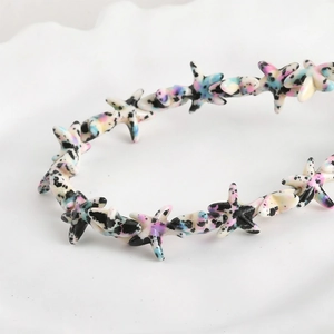Detailed macro of starfish beads with vintage artistic ink texture for DIY jewelry