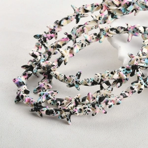 Macro view of star-shaped turquoise beads with pink and blue spots for DIY jewelry