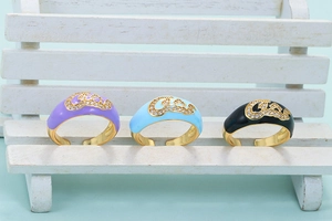 Close-up of three colorful enamel adjustable rings with micro-set zircon and Arabic script