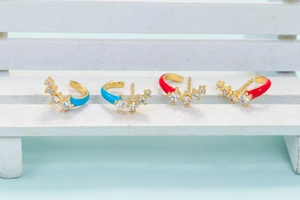 Detail view of colorful enamel and cubic zirconia stones on gold C-shaped earrings