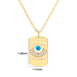 Detalle del colgante rectangular dorado con esmalte de ojo azul y cristales blancos