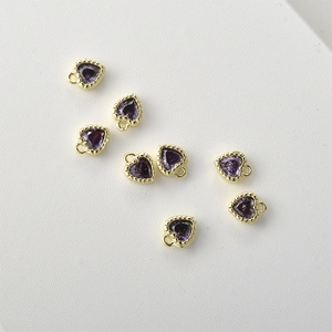Detailed macro of seven purple heart-shaped zircon pendants with 14k gold-plated frames