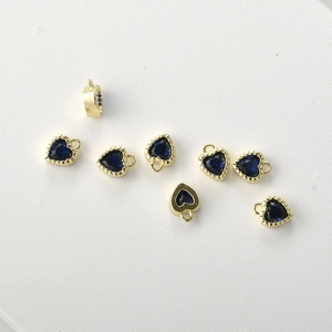 Macro shot of 14k gold-plated heart charms with navy blue cubic zirconia for jewelry DIY