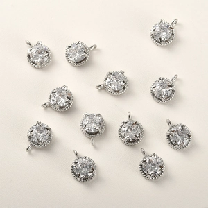 Makroansicht von 11 versilberten Zirkonia-Anhängern mit Milgrain-Rand für DIY-Schmuck