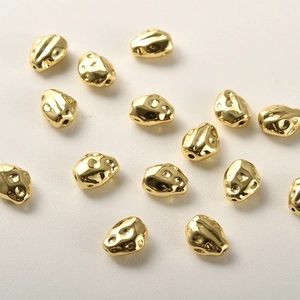 Detalle macro de cuentas irregulares de cobre bañado en oro 14k con textura de lava DIY