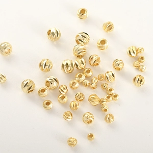 Vista macro di perline rotonde placcate in oro 14k diamantate per creazione gioielli DIY