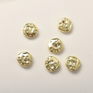 Vista macro de cuentas martilladas bañadas en oro 14k con textura única para joyería DIY