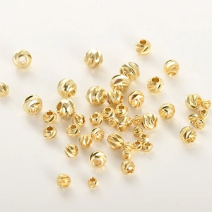 Dettaglio macro di perline distanziatrici sfaccettate placcate oro 14k per gioielli fai da te