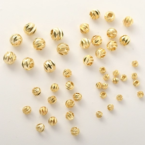 Dettaglio macro di perline sfaccettate placcate oro 14k per la creazione di gioielli