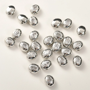 Vista macro di perle a cuore in metallo argentato con zircone ovale per gioielli fai-da-te