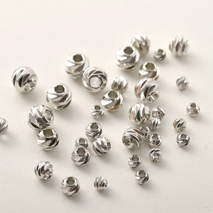 Dettaglio macro di perline distanziatrici argentate sfaccettate per la creazione di gioielli
