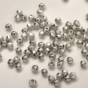 Makro-Detail von geriffelten Silbermetallperlen mit vertikalen Streifen für DIY-Schmuck
