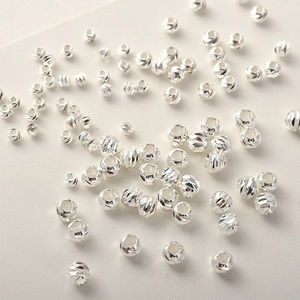 Vista macro di perle placcate argento con dettagli sfaccettati per creare gioielli