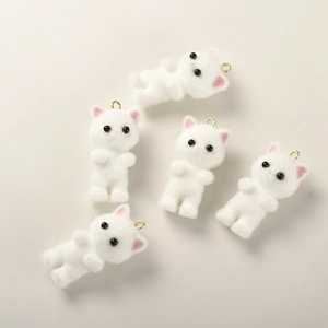Close-up of five cute white flocked resin cat charms for DIY jewelry and crafts