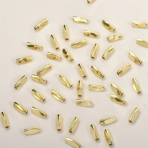Macro shot of gold-plated twisted tube beads for DIY jewelry making and necklaces