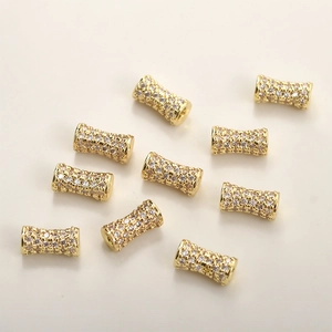 Macro detail of 14k gold-plated cylinder spacer beads with pavé set white zircon for DIY