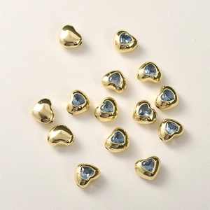 Dettaglio di perline a cuore placcate oro 14k con zircone blu per creazioni di gioielli