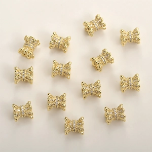 Macro detail of 14k gold plated bow-shaped spacer beads with sparkling zircon stones