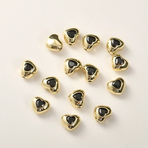 Dettaglio di perline a cuore placcate oro 14k con zircone nero per creazione gioielli DIY