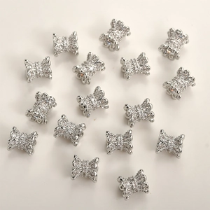 Macro view of silver-plated bow tie spacers with sparkling micro-pave cubic zirconia