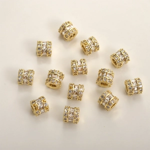 Detailed view of 14k gold-plated cylinder spacer beads with pavé-set white zircon stones