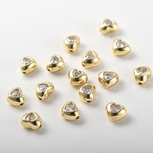 Vista macro di perline a cuore placcate oro 14k con zircone per la creazione di gioielli