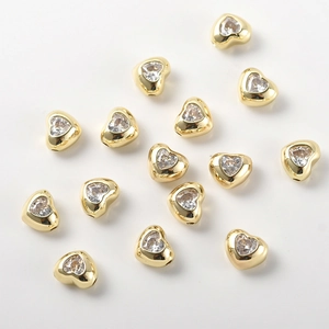 Dettaglio di perline a cuore placcate in oro con zirconia per creazione gioielli