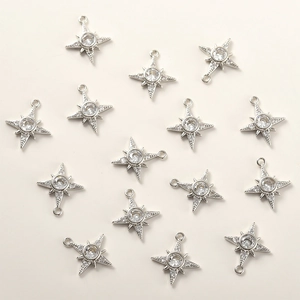 Detailed view of silver star charms with cubic zirconia for DIY jewelry making