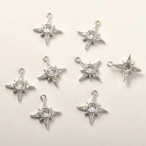 Macro view of 8 pieces of silver star charms with sparkling cubic zirconia for DIY jewelry